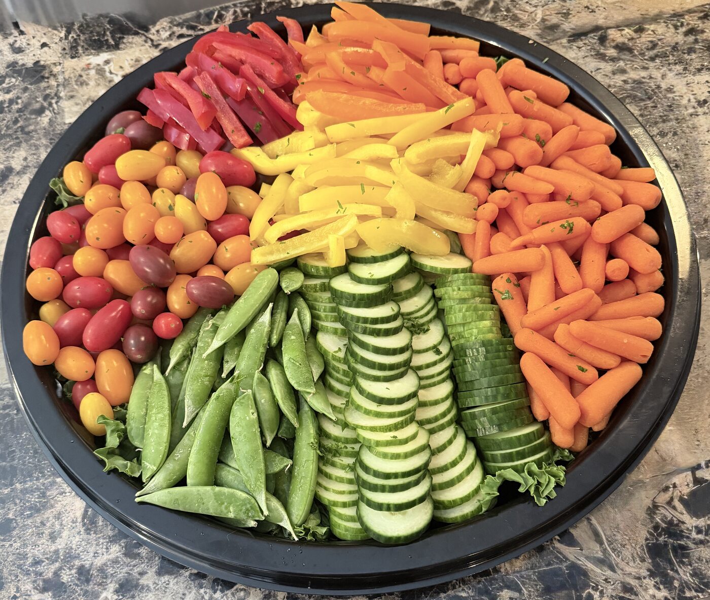 Fresh vegetable crudite platter with peppers, snap peas, cucumber and carrots